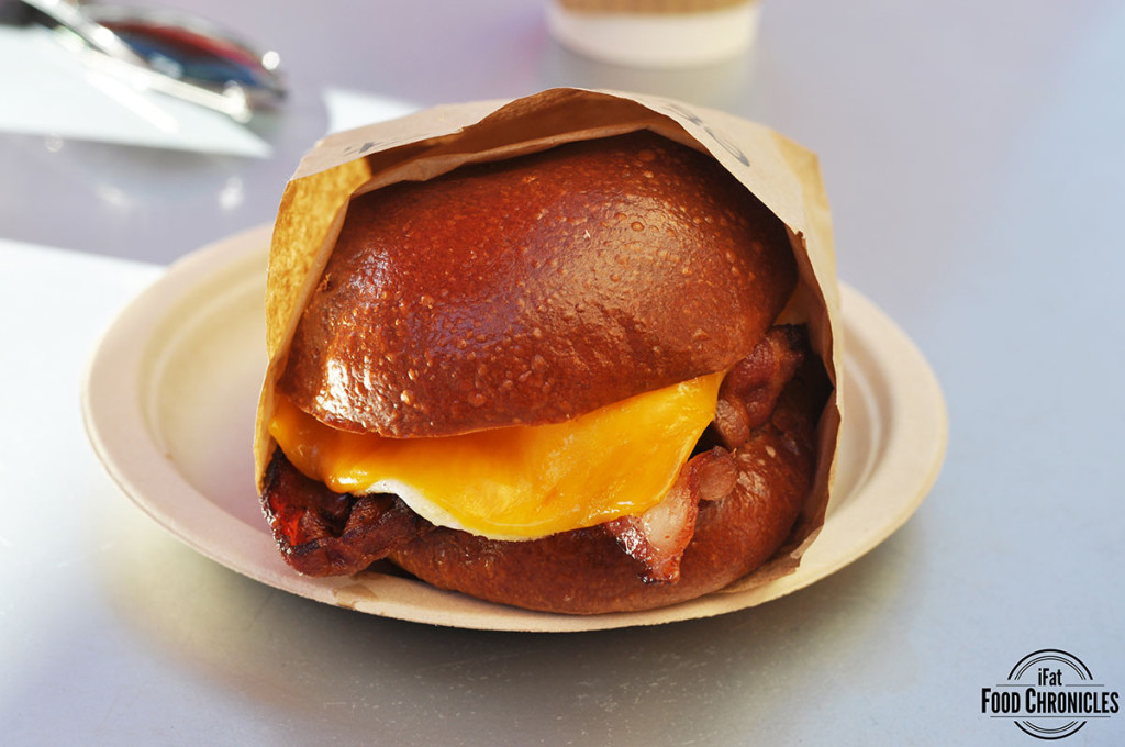 Bacon egg and cheese sandwich with hardwood smoked bacon, over medium egg, cheddar cheese and chipotle ketchup in a warm brioche bun